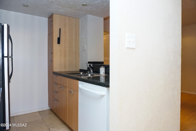 kitchen with white dishwasher, light hardwood / wood-style flooring, fridge, sink, and a textured ceiling