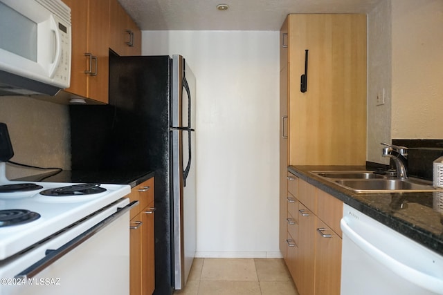 kitchen featuring light tile patterned floors, white appliances, and sink