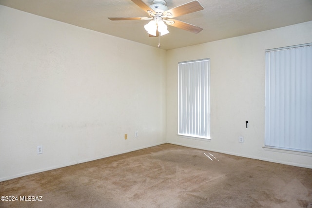 carpeted spare room with ceiling fan