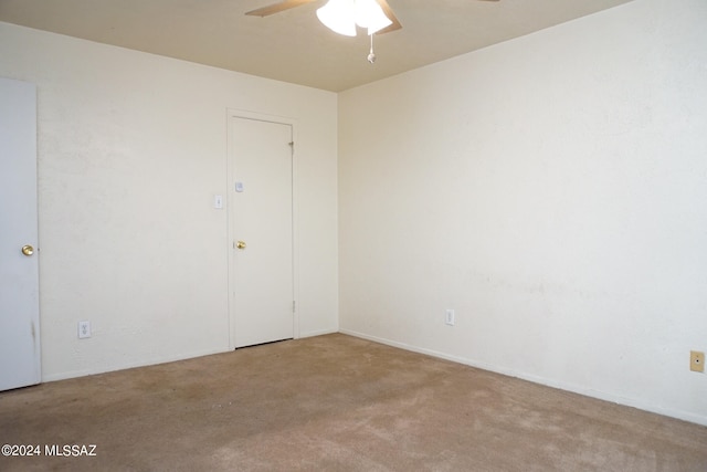 spare room with light colored carpet and ceiling fan