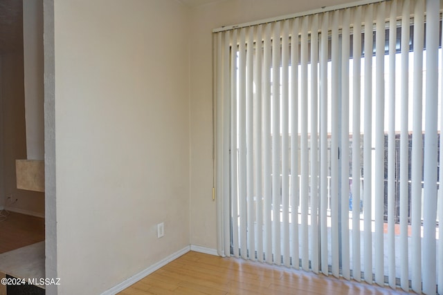 spare room with light wood-type flooring and plenty of natural light