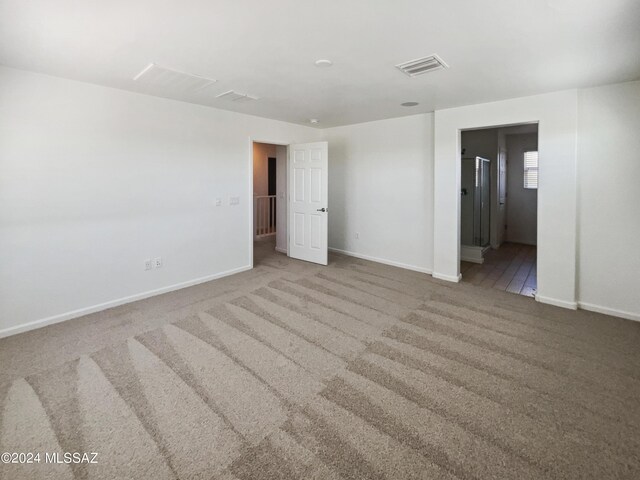 carpeted empty room with visible vents and baseboards