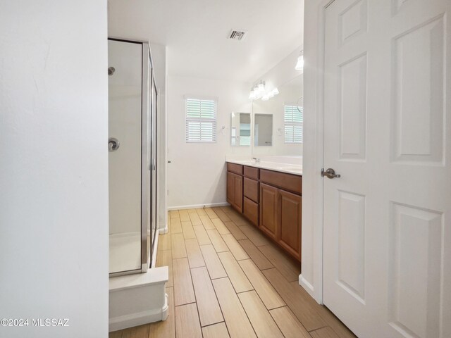 full bathroom with vanity, visible vents, baseboards, wood finish floors, and a shower stall