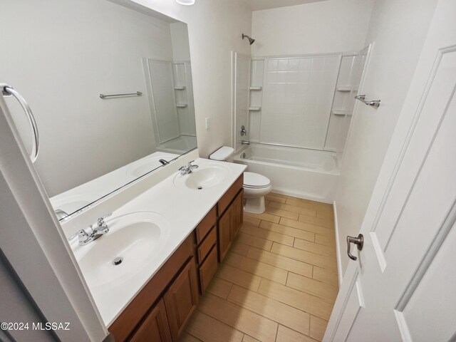 full bathroom featuring a sink, shower / bathing tub combination, toilet, and double vanity