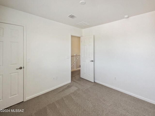 unfurnished bedroom with visible vents, carpet flooring, and baseboards