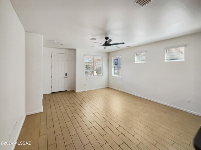 unfurnished room featuring visible vents, light wood-style flooring, baseboards, and ceiling fan