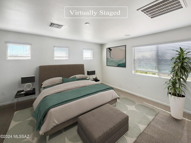 bedroom featuring visible vents, multiple windows, and baseboards