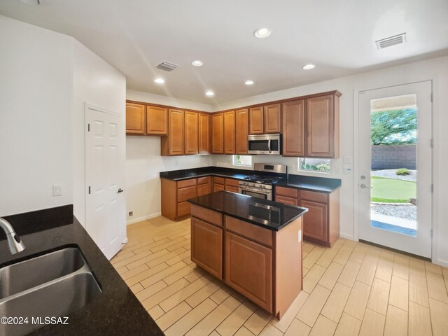 kitchen with brown cabinetry, visible vents, appliances with stainless steel finishes, and a sink