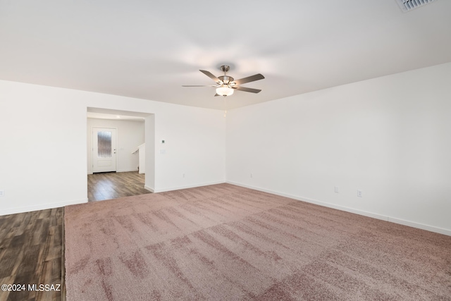 empty room featuring dark wood-type flooring and ceiling fan