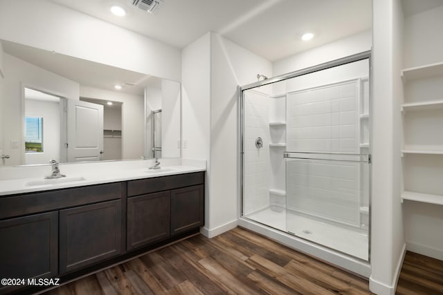 bathroom featuring a shower with shower door, hardwood / wood-style floors, and vanity