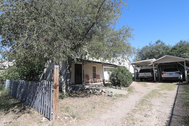 view of side of property with covered porch and a carport