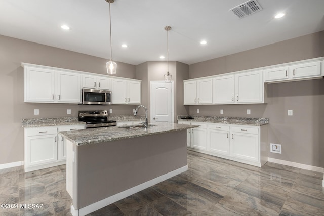 kitchen featuring white cabinets, stainless steel appliances, and an island with sink