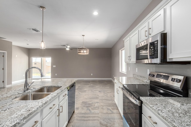 kitchen with light stone countertops, pendant lighting, stainless steel appliances, sink, and white cabinets