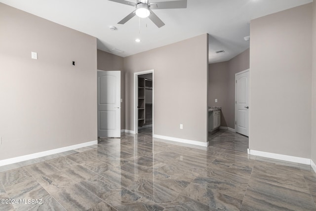 interior space with a walk in closet, ceiling fan, and a closet