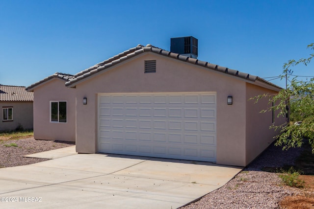 exterior space with cooling unit and a garage