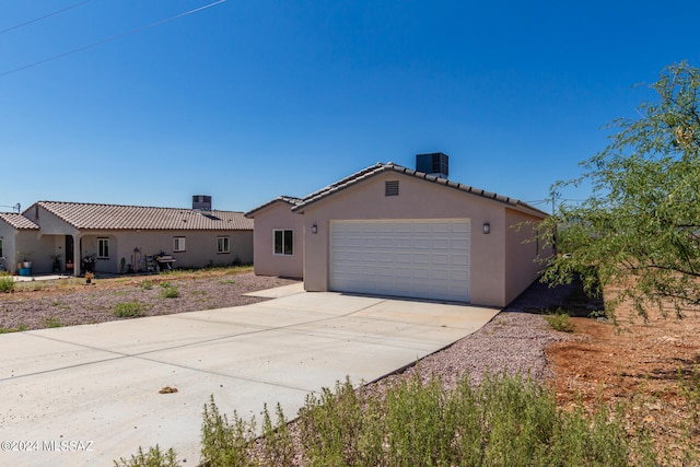 view of front of house featuring a garage and cooling unit