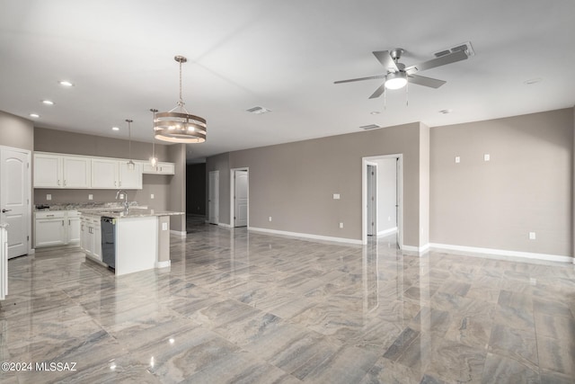 kitchen featuring hanging light fixtures, ceiling fan with notable chandelier, white cabinetry, black dishwasher, and a kitchen island with sink