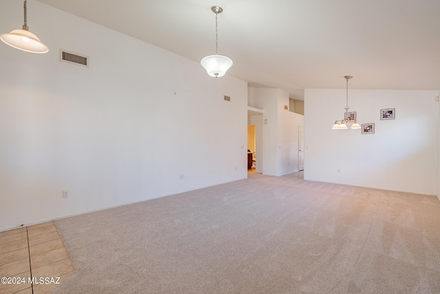 carpeted spare room with lofted ceiling