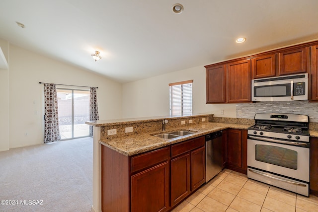 kitchen with stainless steel appliances, light carpet, sink, lofted ceiling, and kitchen peninsula