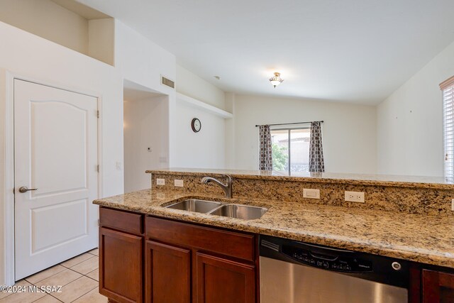 kitchen with light stone countertops, stainless steel dishwasher, sink, lofted ceiling, and light tile patterned flooring