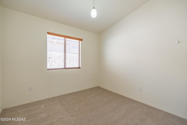 carpeted empty room featuring lofted ceiling