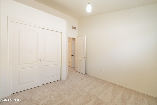 unfurnished bedroom with a closet and light carpet