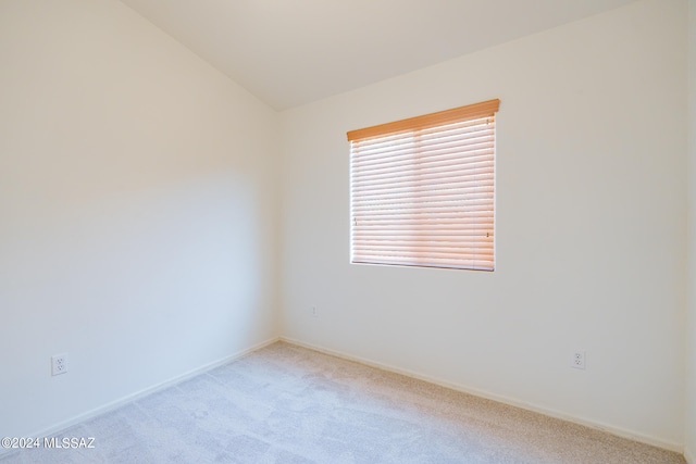 empty room featuring light carpet and lofted ceiling