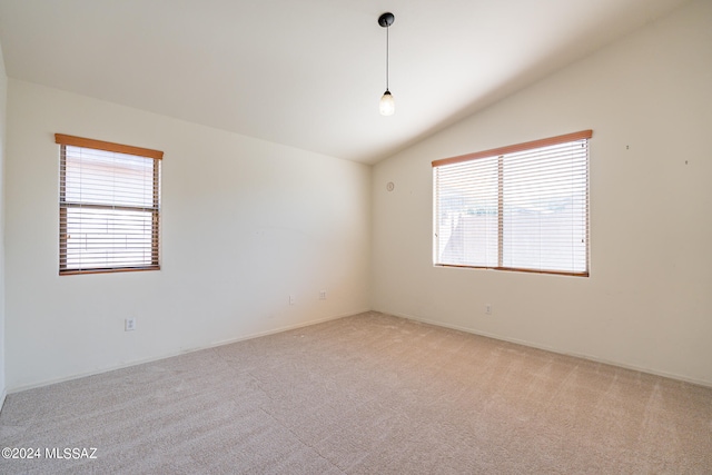 unfurnished room featuring vaulted ceiling and light colored carpet