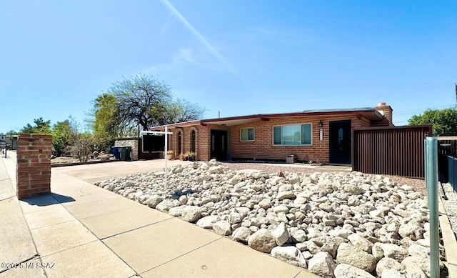 single story home featuring brick siding and fence