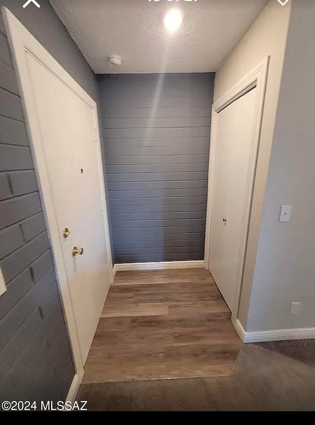 hallway featuring a textured ceiling and wood-type flooring