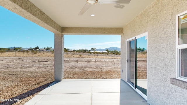 view of patio featuring ceiling fan and a mountain view