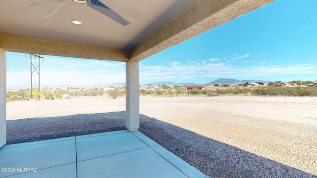 view of patio with a mountain view and ceiling fan