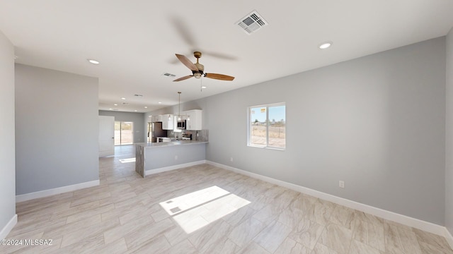 unfurnished living room with ceiling fan