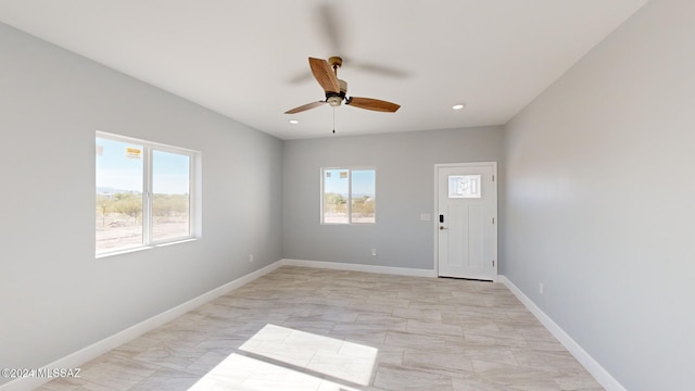 unfurnished room with ceiling fan and a healthy amount of sunlight