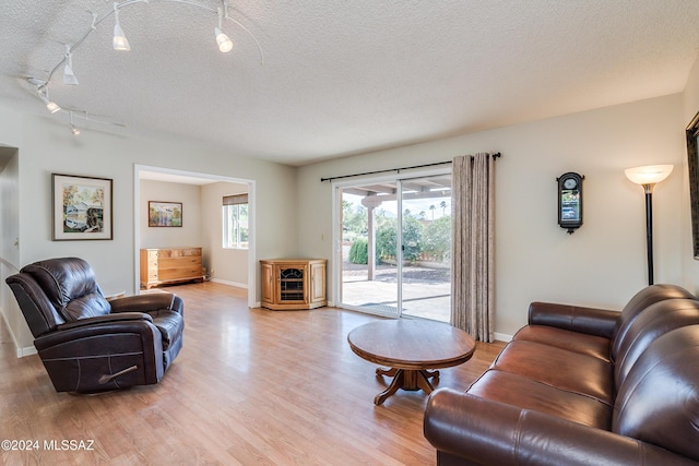 living room featuring light hardwood / wood-style flooring and a textured ceiling