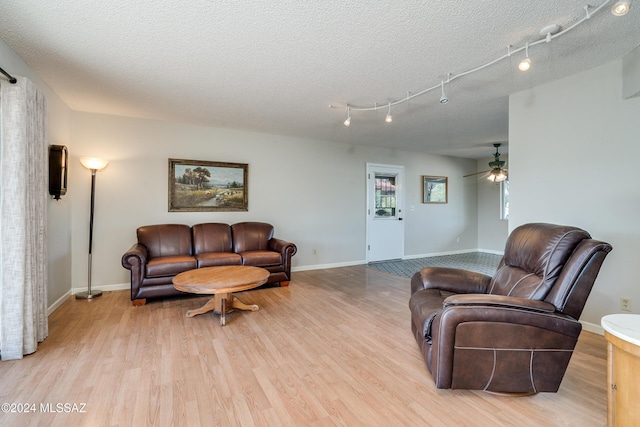 living room featuring a textured ceiling, light hardwood / wood-style floors, and ceiling fan