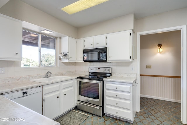 kitchen featuring dishwasher, stainless steel electric range, white cabinetry, and sink