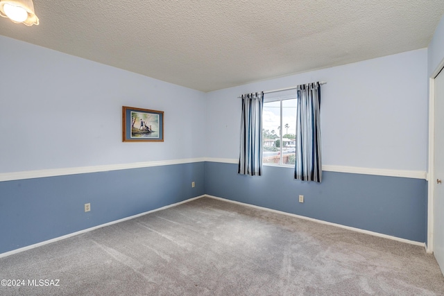 spare room with carpet flooring and a textured ceiling