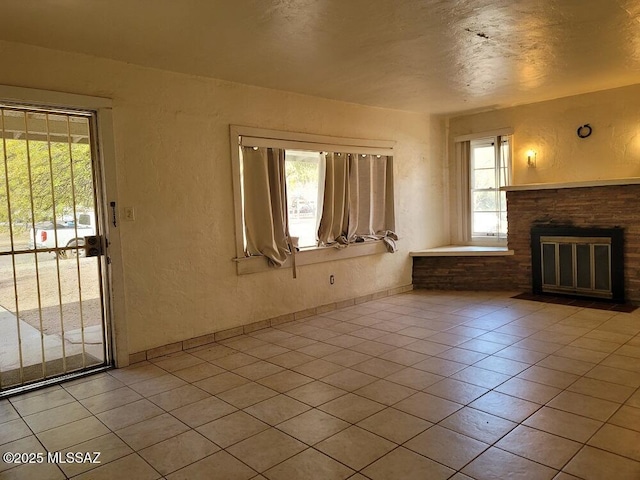 unfurnished living room with light tile patterned flooring and a textured ceiling