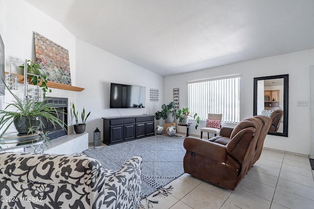 tiled living room with lofted ceiling and a tiled fireplace