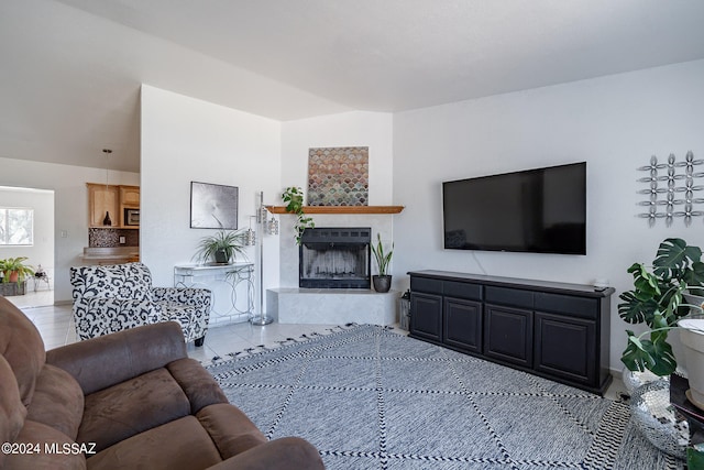 living room with a fireplace and light tile patterned floors