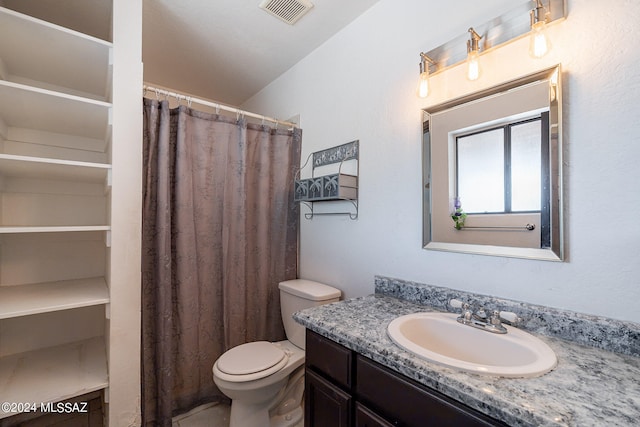 bathroom featuring vanity, lofted ceiling, and toilet