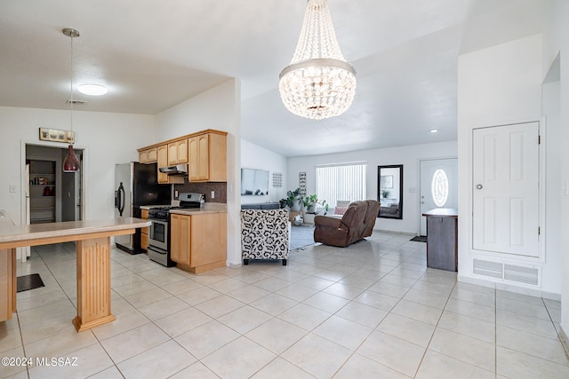 kitchen featuring appliances with stainless steel finishes, hanging light fixtures, light tile patterned flooring, and light brown cabinets