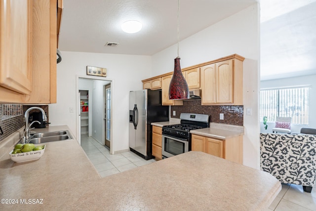 kitchen featuring light tile patterned flooring, light brown cabinets, stainless steel appliances, lofted ceiling, and sink