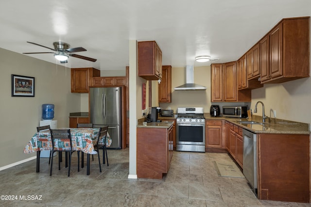 kitchen with appliances with stainless steel finishes, ceiling fan, wall chimney exhaust hood, and sink