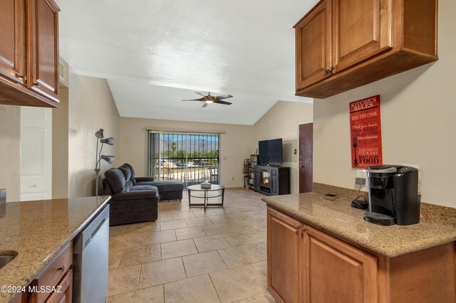 kitchen with light stone counters, lofted ceiling, light tile patterned flooring, ceiling fan, and stainless steel dishwasher