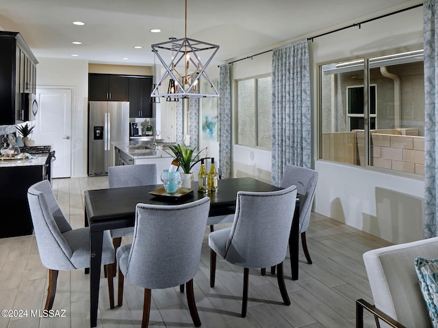 dining room with light hardwood / wood-style floors and an inviting chandelier