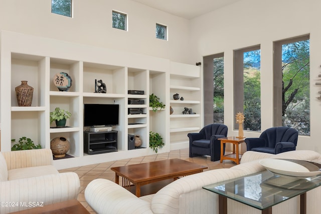 living room featuring a towering ceiling and built in shelves