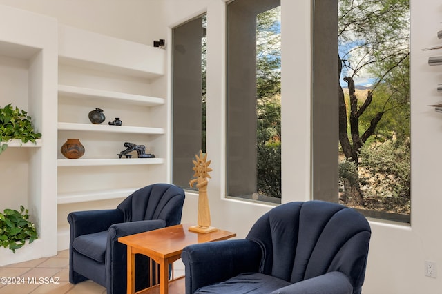 sitting room featuring light tile patterned flooring and built in features