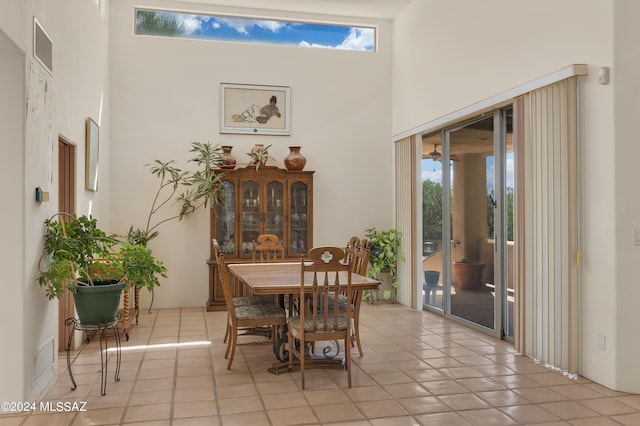 dining room featuring light tile patterned floors and a high ceiling